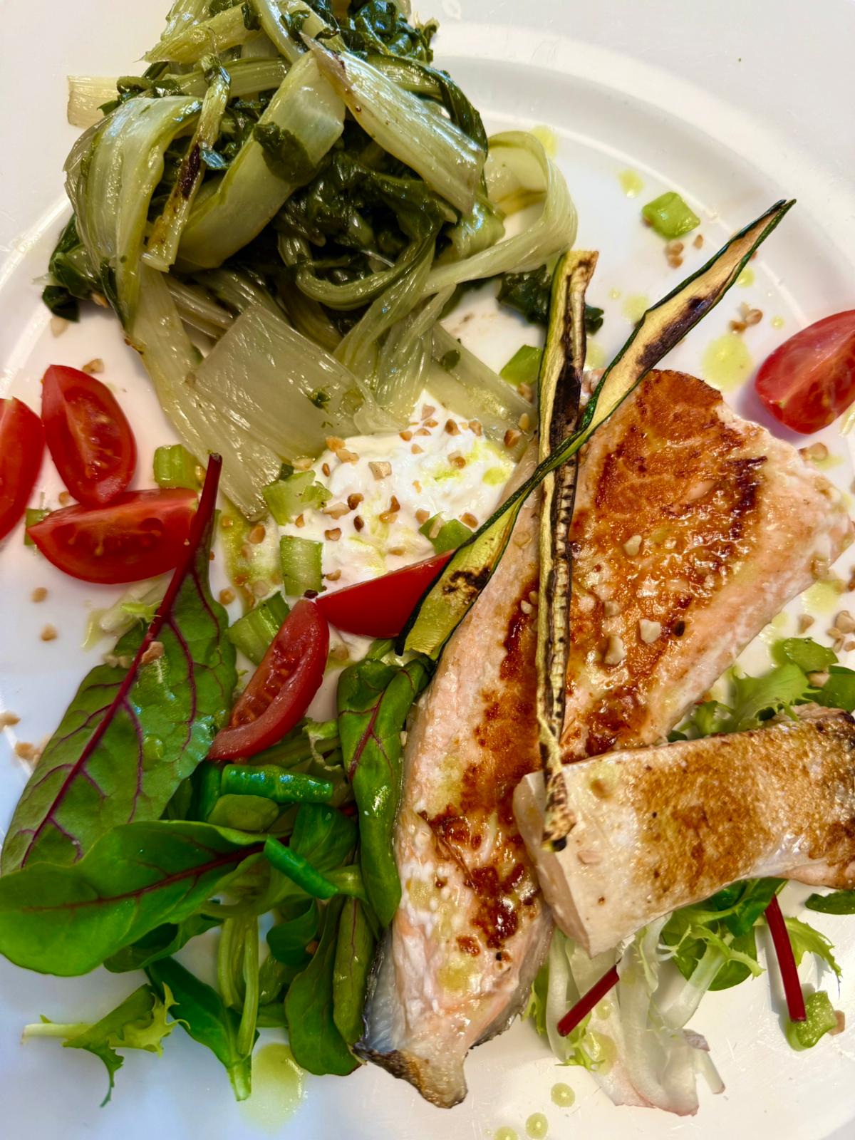 Pesce grigliato con verdure fresche e pomodorini